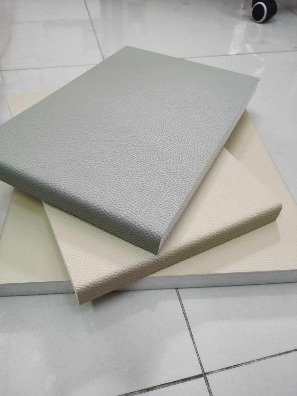 灰色与米色荔枝纹皮革防撞软包墙板样品,高密度海绵填充,适用于办案区审讯室防撞防自伤