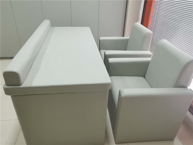 办案区审讯室米白色皮革软包防撞桌椅,高密度海绵填充圆角防撞设计,防止碰撞自伤
