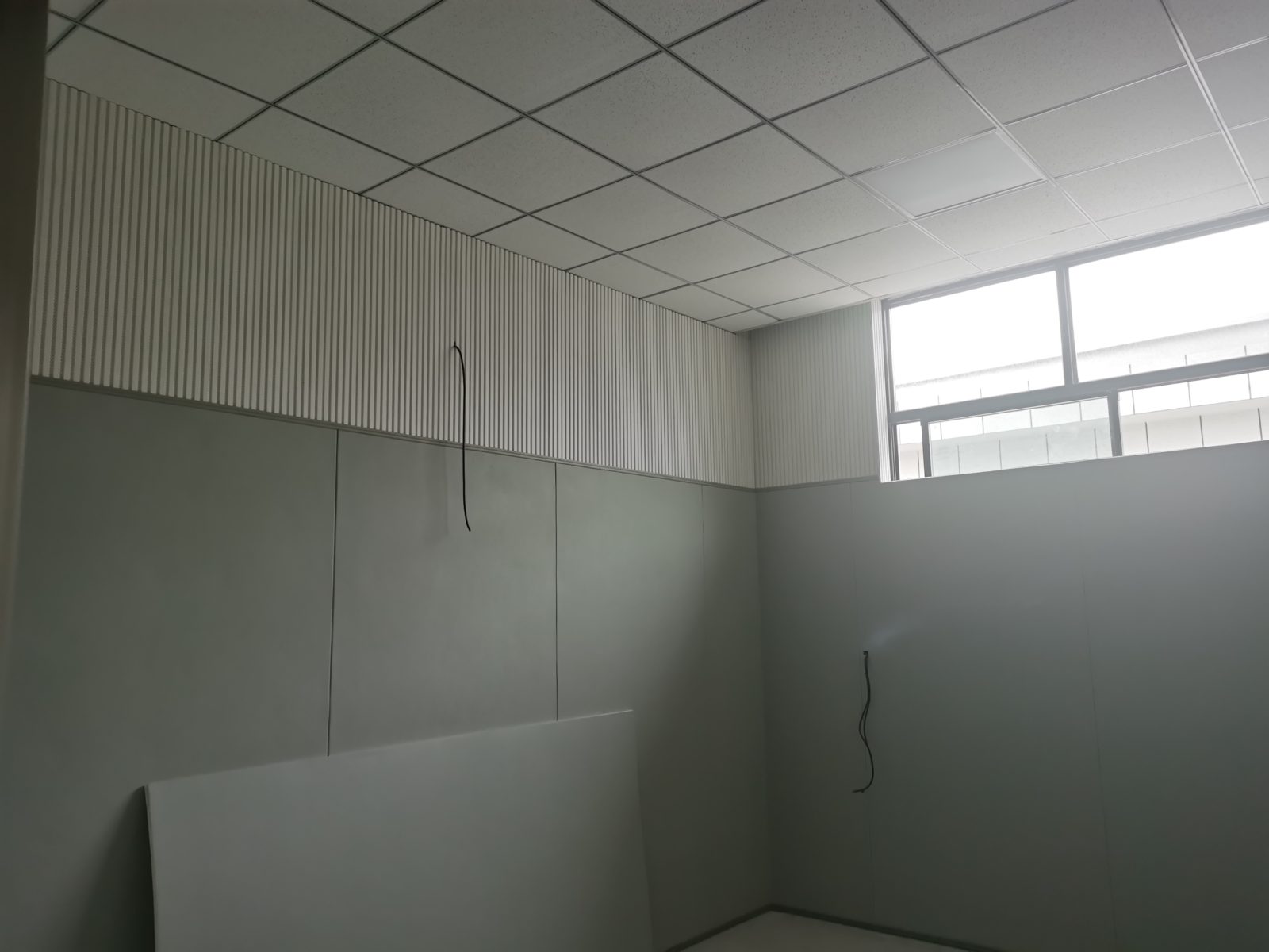 办案区谈话室防撞软包墙面搭配白色木条吸音板安装实景,防撞声学双重处理