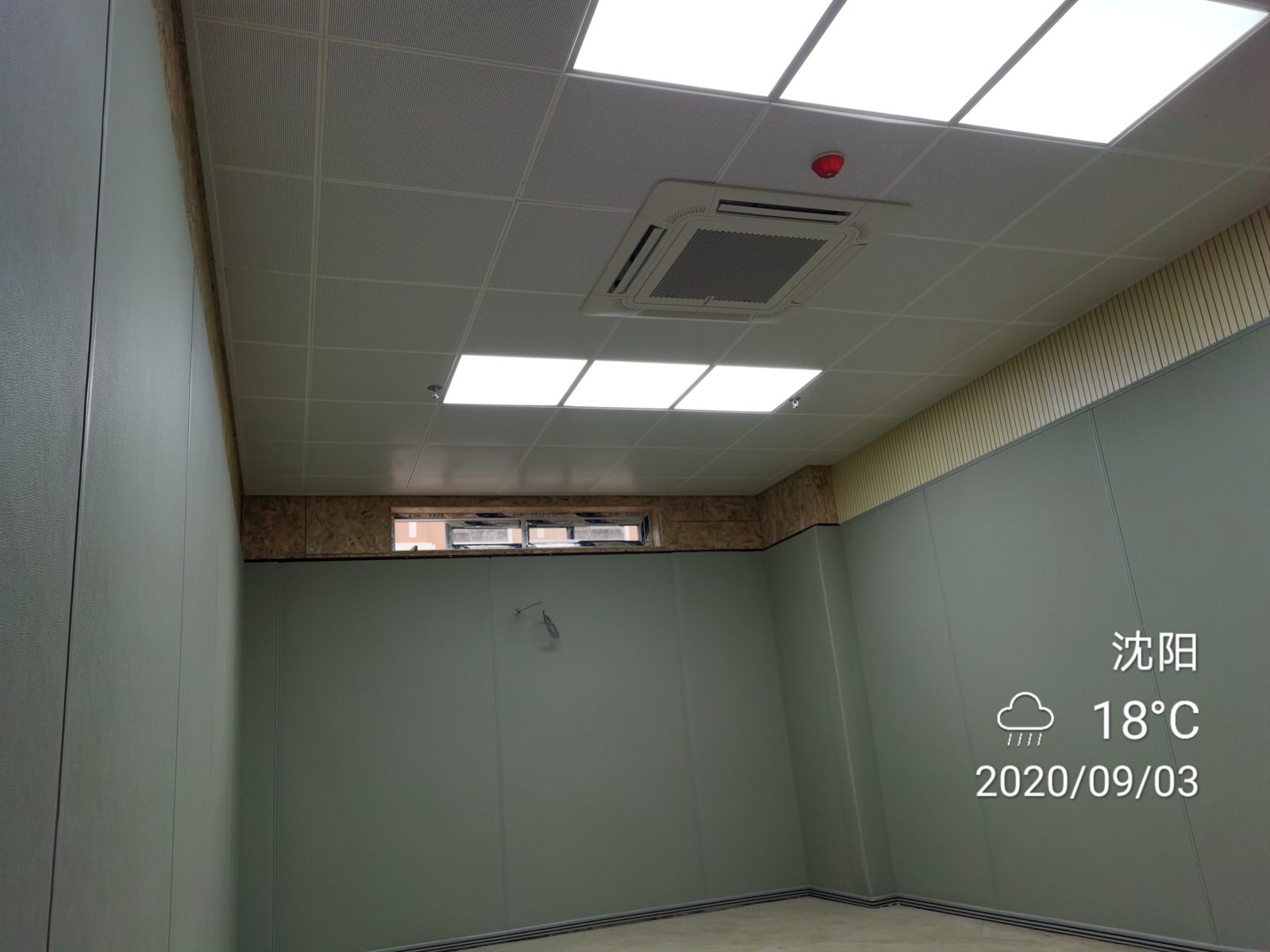 办案区审讯室防撞软包墙面安装实景，灰色软包墙板满铺墙面搭配穿孔吸音吊顶