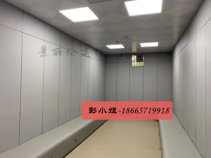 留置室灰色防撞软包墙面装修实景,软包墙板搭配一体化防撞坐凳,适用于办案区谈话室
